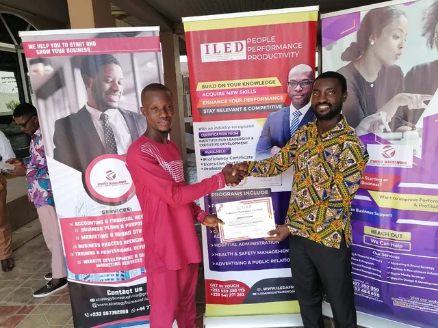 A participant dressed in red receiving a certificate